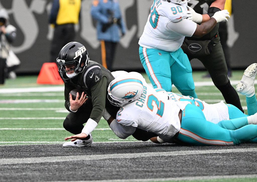 Jets quarterback Brady Cook (4) is forced out of the pocket and runs the ball, getting tackled by Dolphins outside linebacker Bradley Chubb (2) during the third quarter of the Jets and Miami Dolphins game in East Rutherford, NJ.