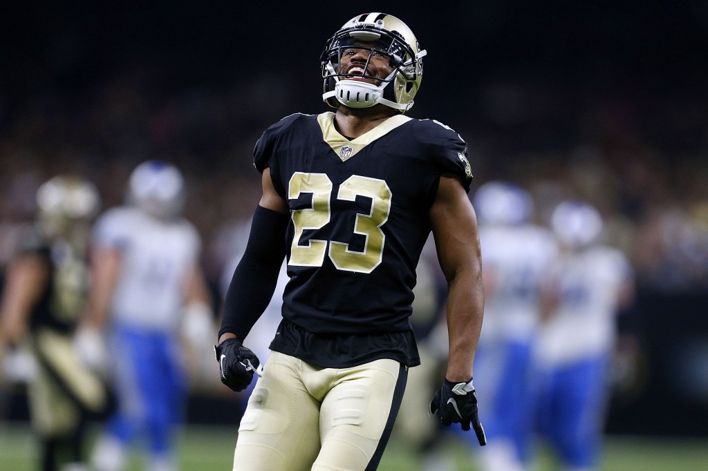 New Orleans Saints player P.J. Williams in a black and gold uniform with number 23, looks up and smiles.