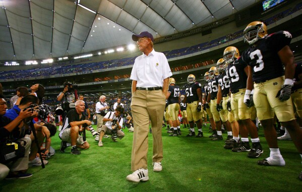 Notre Dame football coach Lou Holtz and his team players await before the start of their game against Japan's national American football team at the Notre Dame Japan Bowl in Tokyo, Saturday, July 25, 2009. (AP Photo/Junji Kurokawa, File)