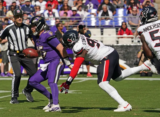 Oct 5, 2025; Baltimore, Maryland, USA; Baltimore Ravens quarterback Cooper Rush (15) is sacked by Houston Texans defensive tackle Mario Edwards (97) during the second quarter at M&T Bank Stadium. Mandatory Credit: Mitch Stringer-Imagn Images