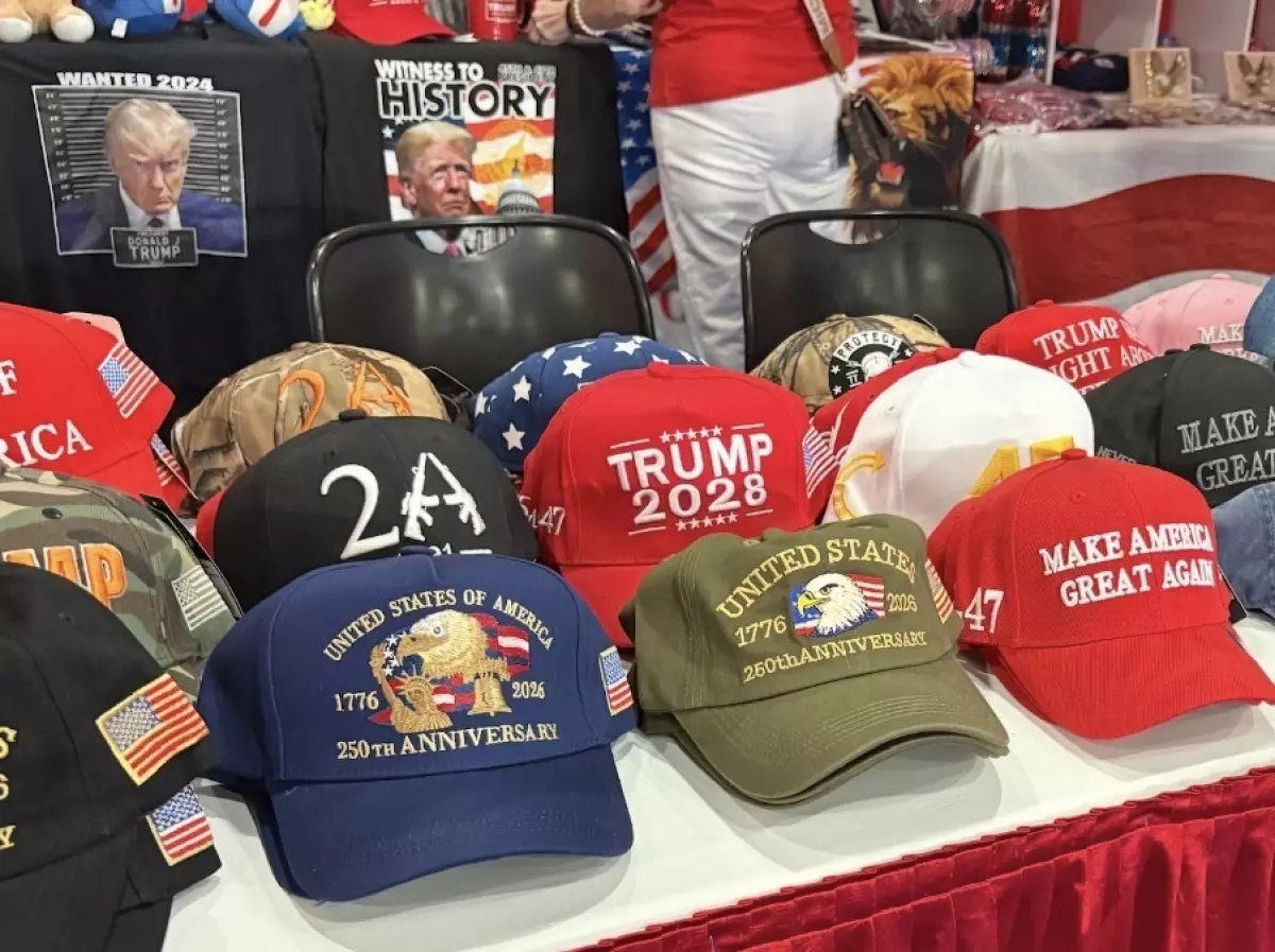 A vendor booth showcases pro-Trump hats and apparel, including 'Make America Great Again' and 'Trump 2028' merchandise, at CPAC.