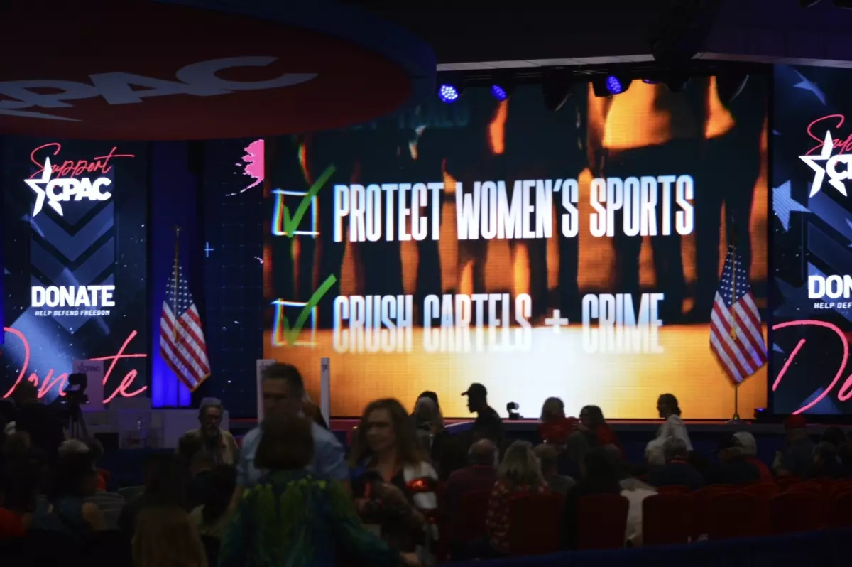 Attendees gather inside the main ballroom as a large screen highlights conservative policy priorities during CPAC.