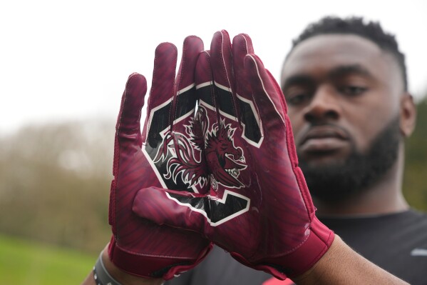 Oluwanifemi 'Neff' Giwa wears South Carolina 'Gamecocks" gloves as he takes part in a football workout session at the National Sports Center, Crystal Palace in London, Sunday, March 29, 2026. (AP Photo/Alastair Grant)