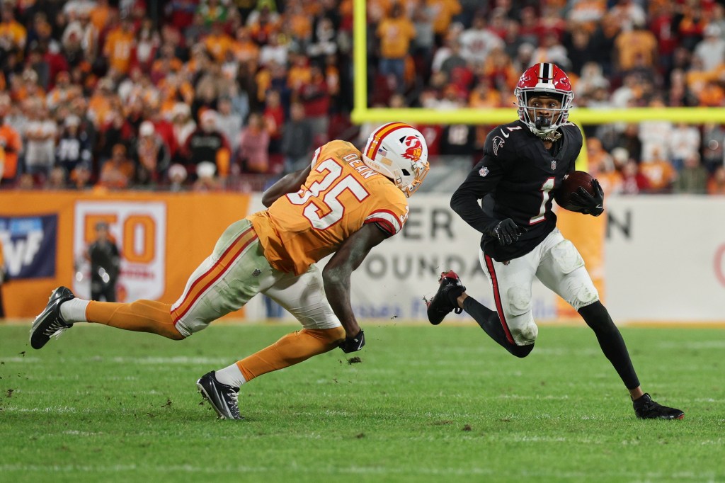 A Tampa Bay Buccaneers defender attempts to tackle an Atlanta Falcons player carrying the football.