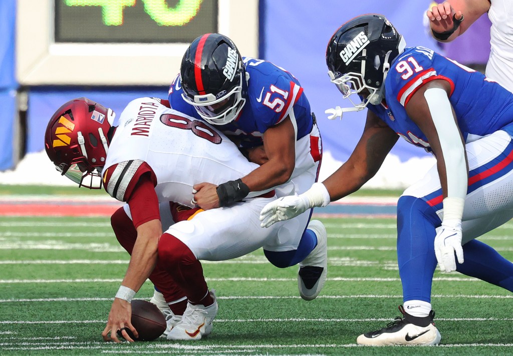 New York Giants player #51 tackles Washington Commanders player #8 Marcus Mariota.