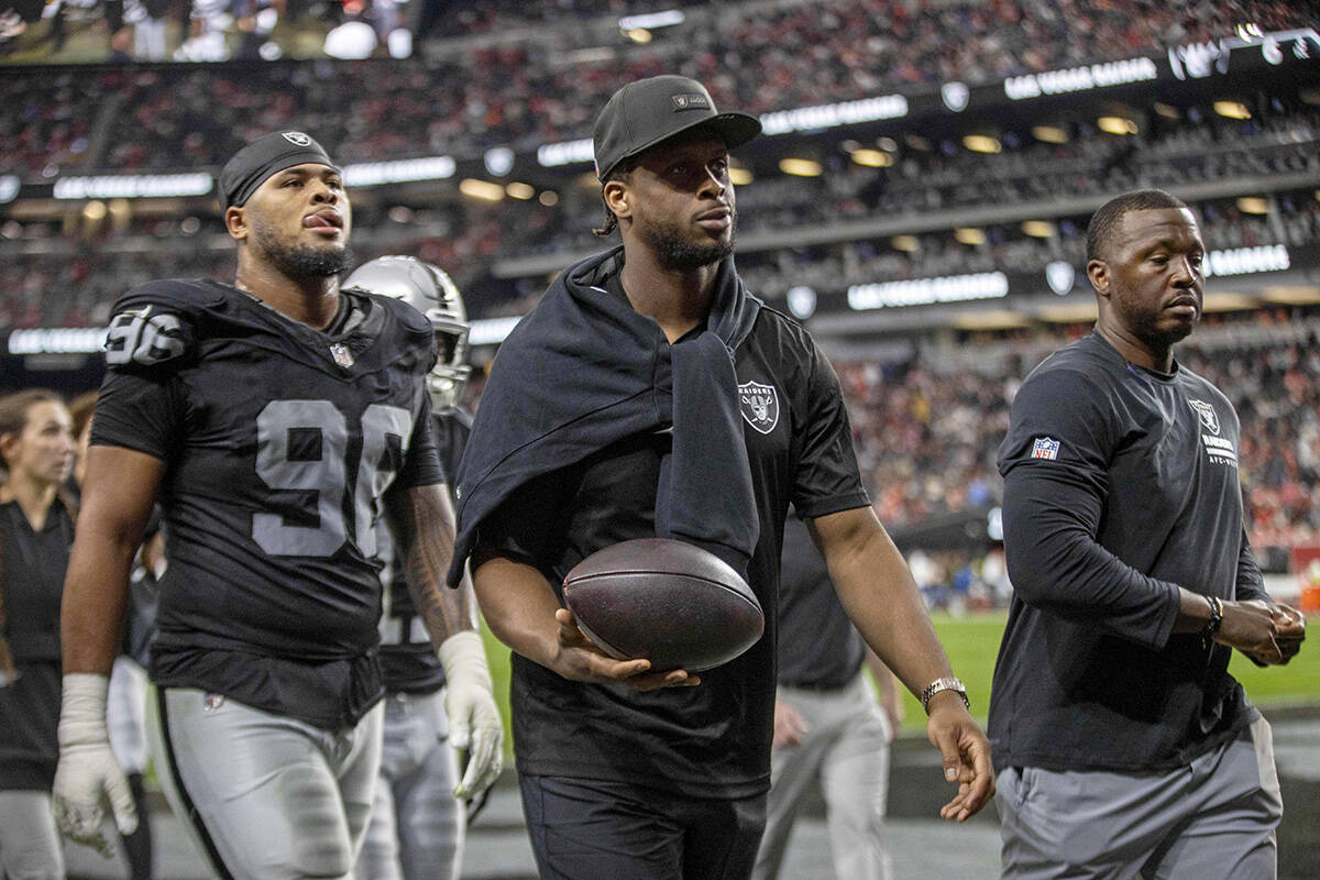 Raiders quarterback Geno Smith (7), center, walks off the field for halftime an NFL game agains ...