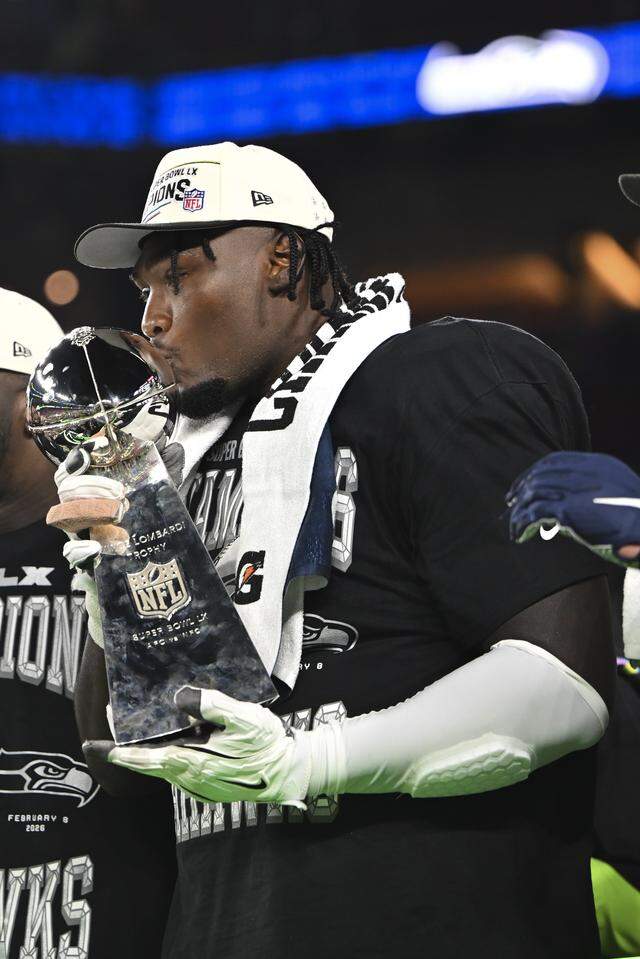 Seattle Seahawks offensive tackle Charles Cross (67) kisses the Lombardi Trophy after beating the New England Patriots 29-13 in Super Bowl LX at Levi's Stadium on Sunday, Feb. 8, 2026, in Santa Clara, Calif.