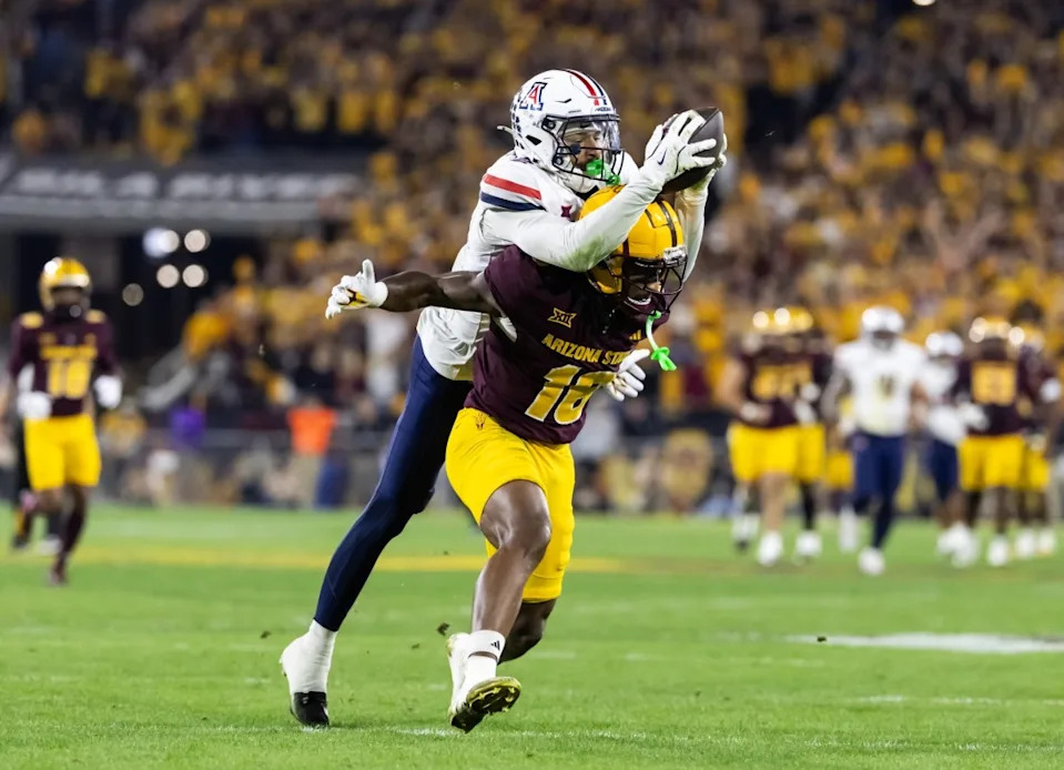 Nov 28, 2025; Tempe, Arizona, USA; Arizona Wildcats defensive back Treydan Stukes (2) intercepts the ball against Arizona State Sun Devils wide receiver Jaren Hamilton (16) in the second half during the 99th Territorial Cup at Mountain America Stadium.