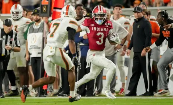 Indiana Hoosiers wide receiver Omar Cooper Jr. (3) runs down the sideline past Miami (FL) Hurricanes defenders Monday, Jan. 19, 2026, during the College Football Playoff National Championship college football game at Hard Rock Stadium in Miami Gardens.