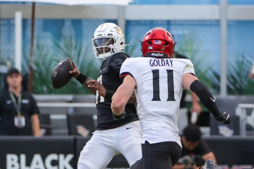 Oct 12, 2024; Orlando, Florida, USA; UCF Knights quarterback Jacurri Brown (11) looks to pass in front of Cincinnati Bearcats linebacker Jake Golday (11) during the second half at FBC Mortgage Stadium. Mandatory Credit: Mike Watters-Imagn Images