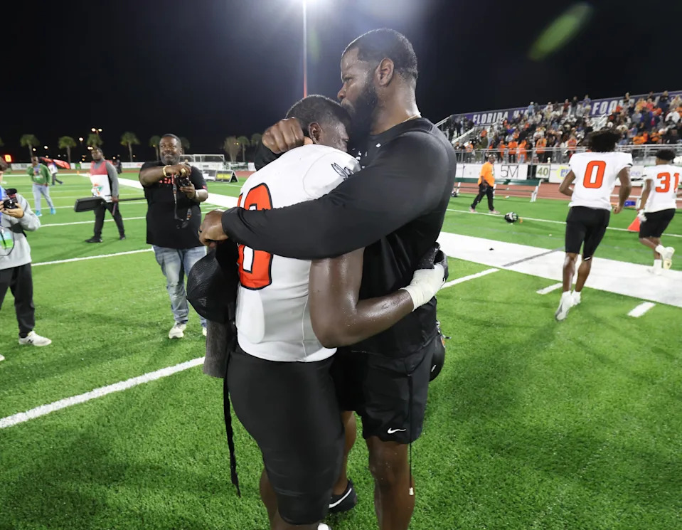 Hawthorne Head Coach Cornelius Ingram give son Hawthorne Kyler Ingram (10) a hug after beating Blountstown 24-8 to win the 2025 FHSAA Rural State Championships at HG Morse Stadium in Sumterville , FL on Friday, December 5, 2025. [Alan Youngblood/Gainesville Sun]