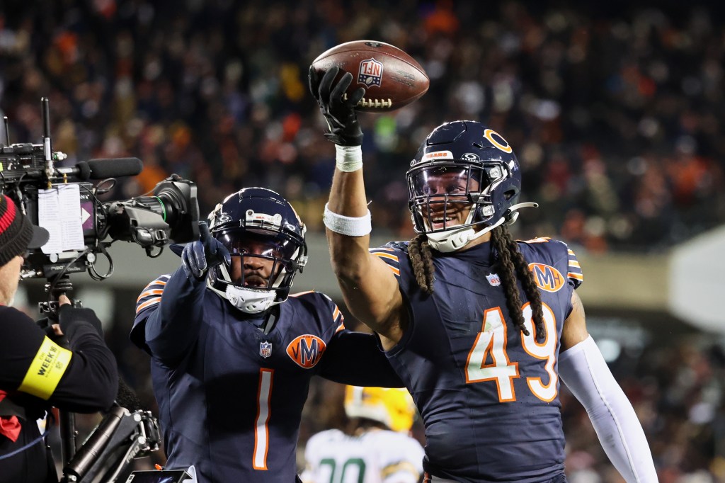 Chicago Bears players Tremaine Edmunds (49) and Jaylon Johnson (1) celebrating a fumble recovery.