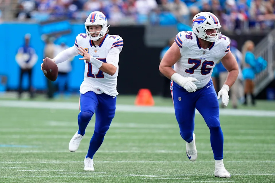 Oct 26, 2025; Charlotte, North Carolina, USA; Buffalo Bills quarterback Josh Allen (17) scrambles behind guard David Edwards (76) during the first half against the Carolina Panthers at Bank of America Stadium. Mandatory Credit: Jim Dedmon-Imagn Images