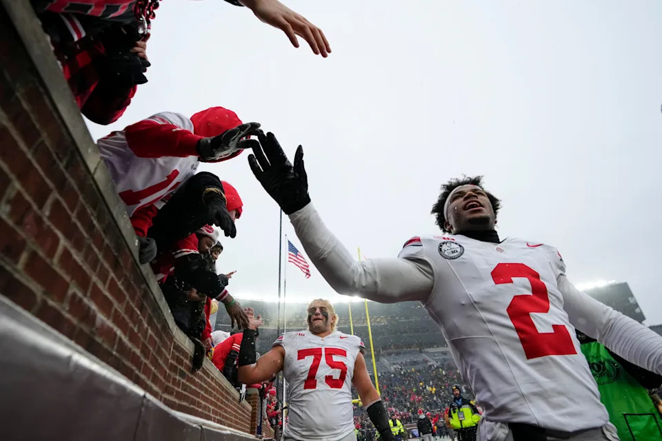 Ohio State Buckeyes defensive back Caleb Downs (2) high fives fans as he leaves the field following the NCAA football game against the Michigan Wolverines at Michigan Stadium in Ann Arbor, Mich. on Nov. 29, 2025. Ohio State won 27-9.
