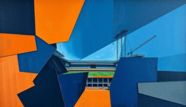 A fractured, cubist-style painting depicting the construction site for a new football stadium, with sharp geometric shapes in navy, orange, and grey representing the various moving parts and stakeholders involved in the project.
