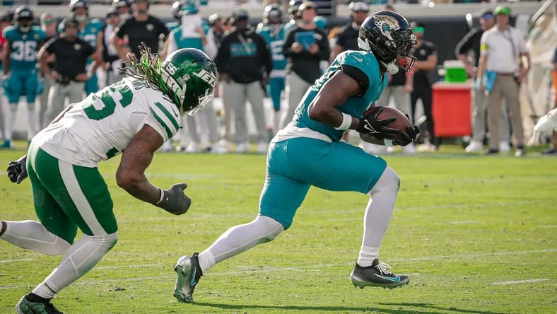 Travis Etienne Jr. running the ball during a Jaguars game against the New York Jets.