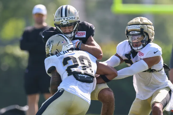 Jul 28, 2025; Metairie, LA, USA; New Orleans Saints wide receiver Mason Tipton (15) is hit on a pass by safety Julian Blackmon (28) at Ochsner Sports Performance Center. Mandatory Credit: Stephen Lew-Imagn Images