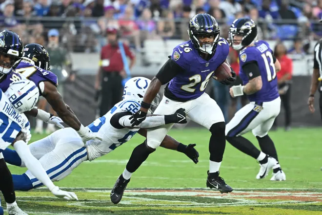 Aug 7, 2025; Baltimore, Maryland, USA; Baltimore Ravens running back Rasheen Ali (26) breaks out of a tackle by Indianapolis Colts defensive end Isaiah Land (55) during the second quarter at M&T Bank Stadium. Mandatory Credit: Rafael Suanes-Imagn Images