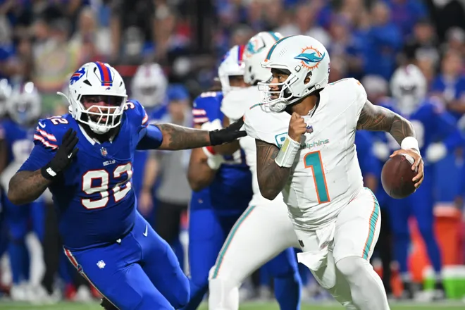 Sep 18, 2025; Orchard Park, New York, USA; Miami Dolphins quarterback Tua Tagovailoa (1) looks to pass against Buffalo Bills defensive tackle Daquan Jones (92) in the first half at Highmark Stadium. Mandatory Credit: Mark Konezny-Imagn Images