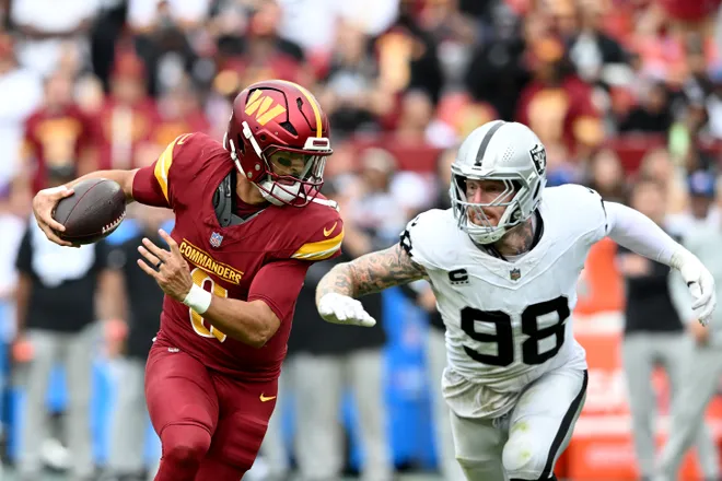 LANDOVER, MARYLAND - SEPTEMBER 21: Marcus Mariota #8 of the Washington Commanders rushes the ball against Maxx Crosby #98 of the Las Vegas Raiders in the fourth quarter at Northwest Stadium on September 21, 2025 in Landover, Maryland. (Photo by Greg Fiume/Getty Images)