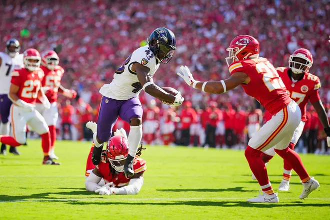 Sep 28, 2025; Kansas City, Missouri, USA; Baltimore Ravens running back Justice Hill (43) evades a tackle from Kansas City Chiefs safety Jaden Hicks (21) to score a touchdown during the first quarter at GEHA Field at Arrowhead Stadium. Mandatory Credit: Jay Biggerstaff-Imagn Images