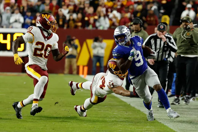 Nov 2, 2025; Landover, Maryland, USA; Seattle Seahawks running back Kenneth Walker III (9) converts a fourth down as Washington Commanders linebacker Bobby Wagner (54) reaches to defend at Northwest Stadium. Mandatory Credit: Geoff Burke-Imagn Images