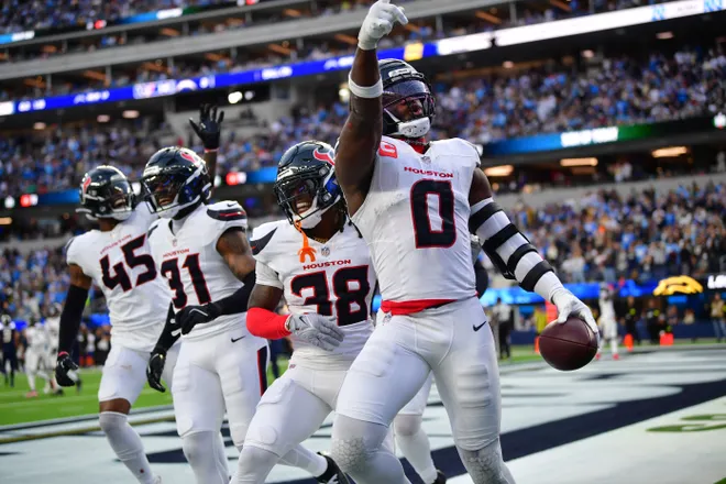 Dec 27, 2025; Inglewood, California, USA; Houston Texans linebacker Azeez al-Shaair (0) reacts with safety K'Von Wallace (38) after making an interception against the Los Angeles Chargers during the first half at SoFi Stadium. Mandatory Credit: Gary A. Vasquez-Imagn Images