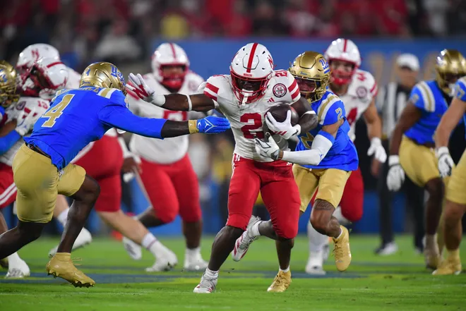 Nov 8, 2025; Pasadena, California, USA; Nebraska Cornhuskers running back Emmett Johnson (21) runs the ball against the UCLA Bruins during the first half at the Rose Bowl. Mandatory Credit: Gary A. Vasquez-Imagn Images