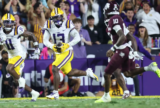 Oct 25, 2025; Baton Rouge, Louisiana, USA; Louisiana State Tigers defensive back A.J. Haulcy (13) returns an interception against Texas A&M Aggies quarterback Marcel Reed (10) during the first half at Tiger Stadium. Mandatory Credit: Stephen Lew-Imagn Images