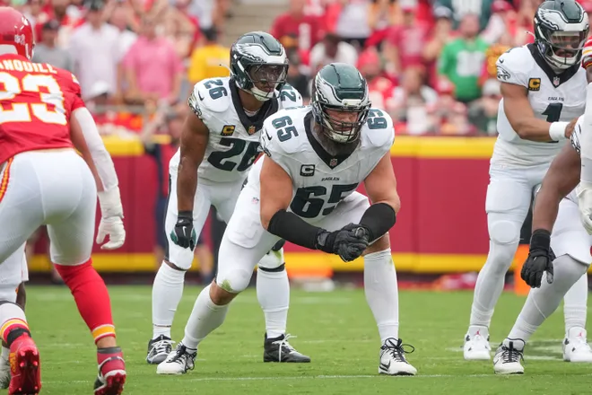 Sep 14, 2025; Kansas City, Missouri, USA; Philadelphia Eagles offensive tackle Lane Johnson (65) and running back Saquon Barkley (26) on the line of scrimmage against the Kansas City Chiefs during the game at GEHA Field at Arrowhead Stadium. Mandatory Credit: Denny Medley-Imagn Images