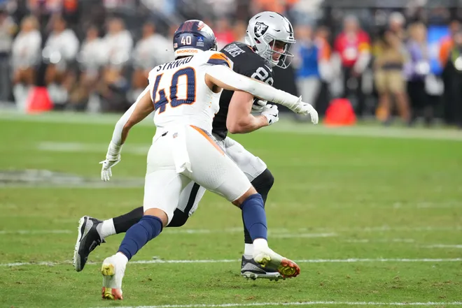 Dec 7, 2025; Paradise, Nevada, USA; Las Vegas Raiders tight end Brock Bowers (89) runs after the catch as Denver Broncos linebacker Justin Strnad (40) defends during the second half at Allegiant Stadium. Mandatory Credit: Stephen R. Sylvanie-Imagn Images