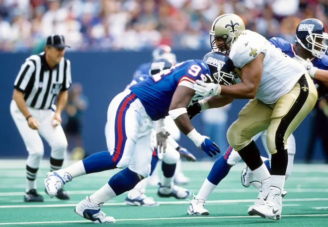 New Orleans Saints tackle Willie Roaf blocks New York Giants defensive end Cedric Jones.