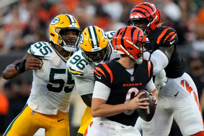 Cincinnati Bengals quarterback Jake Browning (6) escapes pressure rom Green Bay Packers linebacker Kingsley Enagbare (55) and Green Bay Packers defensive tackle Colby Wooden (96) in the second quarter during a Week 1 NFL preseason game between the Green Bay Packers and the Cincinnati Bengals,Friday, Aug. 11, 2023, at Paycor Stadium in Cincinnati.