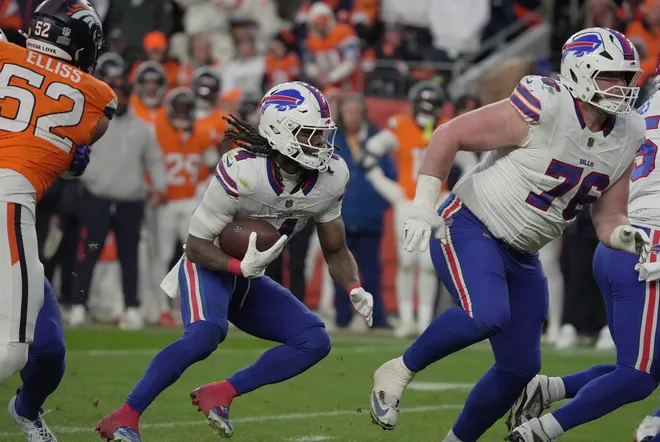 Buffalo Bills running back James Cook III finds an opening and follows guard David Edwards during second half action at Empower FIeld at Mile High in Denver, Colorado on Jan. 17, 2026.