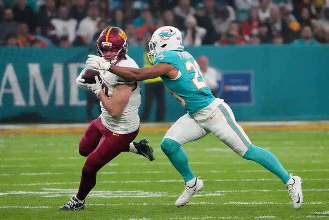 Nov 16, 2025; Madrid, Spain; Washington Commanders tight end Colson Yankoff (80) carries the ball defended by Miami Dolphins safety Minkah Fitzpatrick (29) in the first quarterduring the 2025 NFL Madrid Game at Santiago Bernabeu Stadium. Mandatory Credit: Kirby Lee-Imagn Images