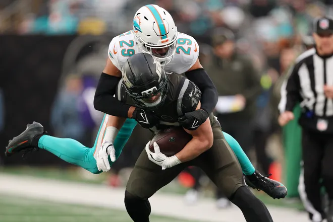 Dec 7, 2025; East Rutherford, New Jersey, USA; Miami Dolphins safety Minkah Fitzpatrick (29) tackles New York Jets fullback Andrew Beck (47) during the second half at MetLife Stadium. Mandatory Credit: Vincent Carchietta-Imagn Images