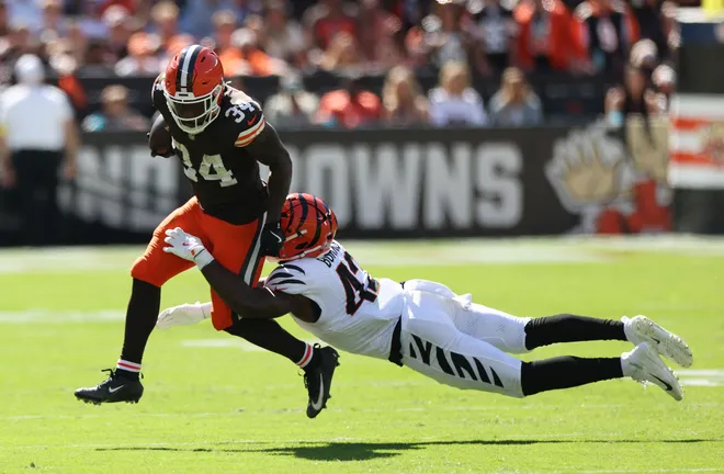 Sep 7, 2025; Cleveland, Ohio, USA; Cleveland Browns running back Jerome Ford (34) is tackled by Cincinnati Bengals linebacker Oren Burks (42) during the second half at Huntington Bank Field. Mandatory Credit: Scott Galvin-Imagn Images
