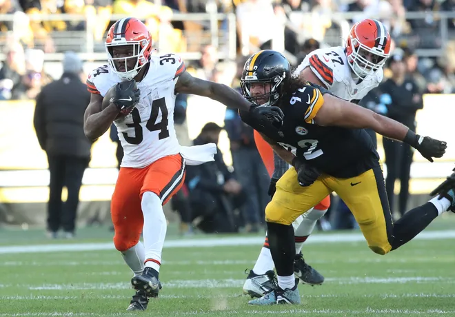 Dec 8, 2024; Pittsburgh, Pennsylvania, USA; Cleveland Browns running back Jerome Ford (34) runs the ball past Pittsburgh Steelers defensive tackle Isaiahh Loudermilk (92) during the third quarter at Acrisure Stadium. Mandatory Credit: Charles LeClaire-Imagn Images
