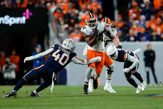 Dec 2, 2024; Denver, Colorado, USA; Cleveland Browns running back Jerome Ford (34) runs through the tackle of Denver Broncos linebacker Justin Strnad (40) in the second quarter at Empower Field at Mile High. Mandatory Credit: Isaiah J. Downing-Imagn Images