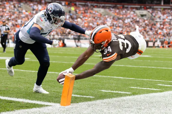 Sep 24, 2023; Cleveland, Ohio, USA; Cleveland Browns running back Jerome Ford (34) dives for a touchdown as Tennessee Titans linebacker Jack Gibbens (50) chases him during the third quarter at Cleveland Browns Stadium. Mandatory Credit: Scott Galvin-USA TODAY Sports
