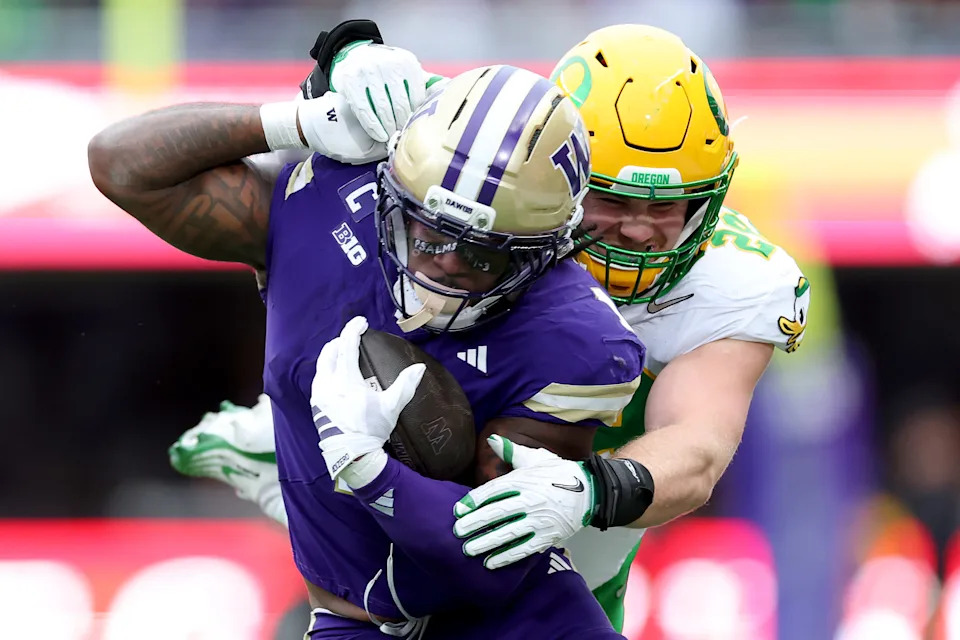 SEATTLE, WASHINGTON - NOVEMBER 29: Jonah Coleman #1 of the Washington Huskies avoids a tackle by Bryce Boettcher #28 of the Oregon Ducks during the first half at Husky Stadium on November 29, 2025 in Seattle, Washington. (Photo by Steph Chambers/Getty Images)