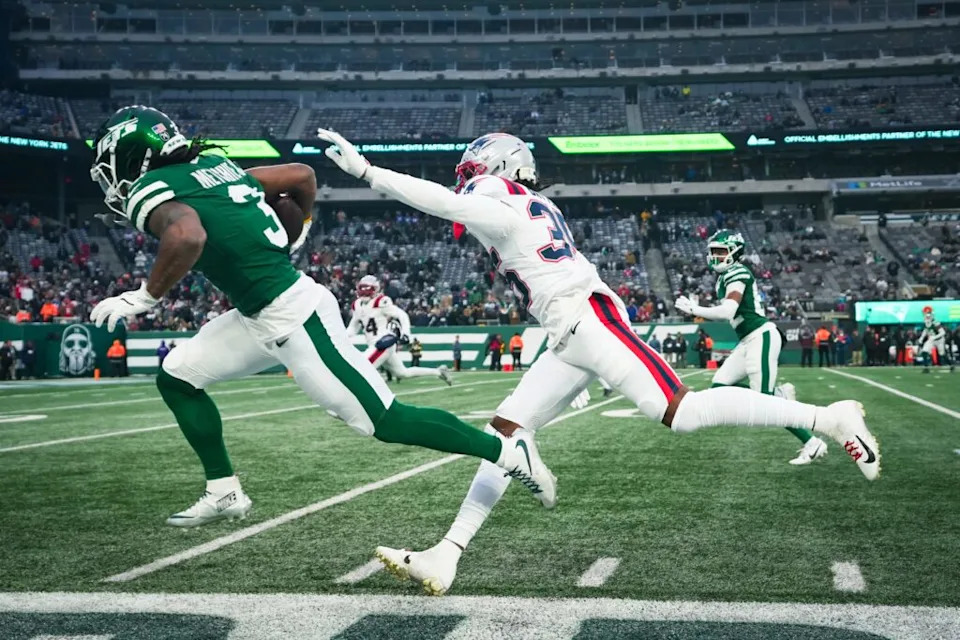New York Jets wide receiver John Metchie III (3) runs the ball as New England Patriots safety John Saunders Jr. (23) defends during a game at MetLife Stadium, Dec 28, 2025, East Rutherford, NJ, USA.