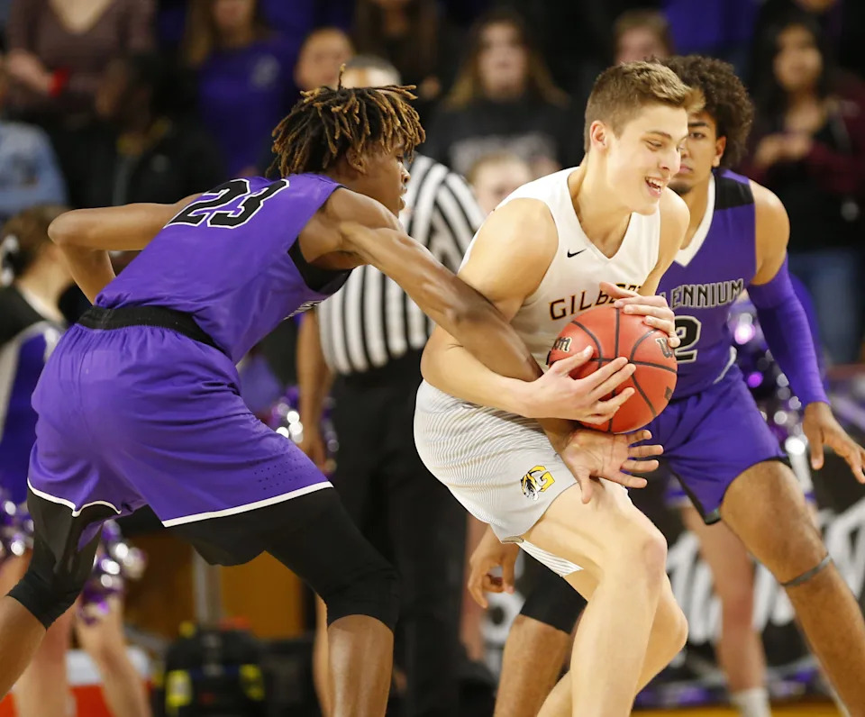 Gilbert's Carson Towt (33) is fouled by Millennium's DaRon Holmes (23) during the Boys State 5A Championship game in Tempe, Ariz. Feb. 25, 2019.