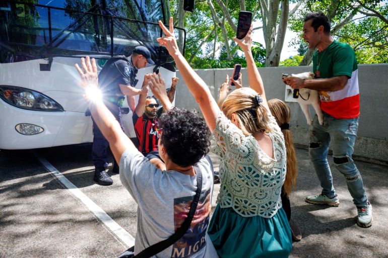 Members of the Iranian community in Australia block the path of a departing bus transporting members of the Iranian Women’s Asia Cup football team to the airport, outside the Royal Pines Resort on the Gold Coast on March 10, 2026. Five players from Iran's visiting women's football team claimed asylum in Australia on March 10, seeking protection after they were branded "traitors" at home for refusing to sing the national anthem. (Photo by Patrick HAMILTON / AFP)