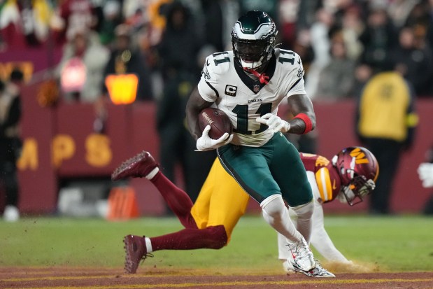 Philadelphia Eagles wide receiver A.J. Brown (11) runs against Washington Commanders cornerback Noah Igbinoghene, bottom, during the first half of an NFL football game, Saturday, Dec. 20, 2025, in Landover, Md. (AP Photo/Stephanie Scarbrough)