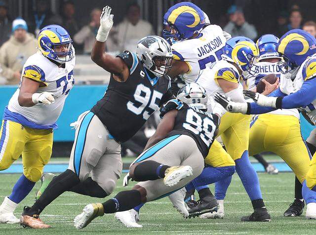 Carolina Panthers defensive tackle Derrick Brown, left, pressures Los Angeles Rams quarterback Matthew Stafford, right, in the pocket at Bank of America Stadium in Charlotte, NC on Sunday, November 30, 2025. Brown would cause Stafford to fumble the ball with the Panthers recovering. The Panthers defeated the Rams 31-28.