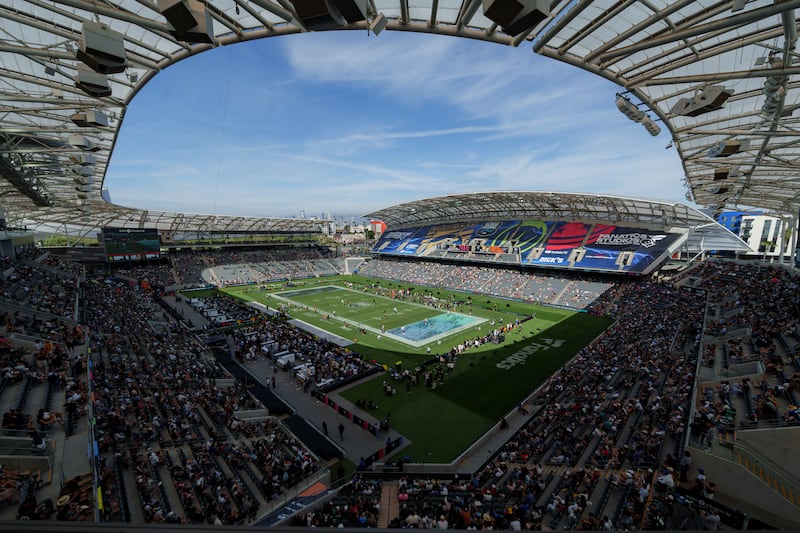 Wide establishing shot of BMO Stadium at the Fanatics Flag Football Classic with blue skies overhead and fans in seats.