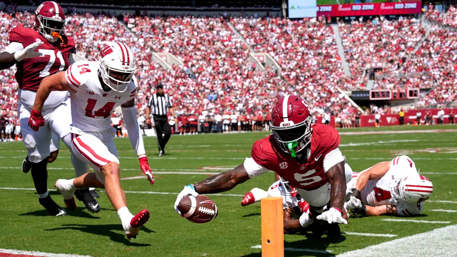 Alabama wide receiver Germie Bernard (5) dives for a score at the pylon with Wisconsin defensive back Preston Zachman (14), Wisconsin defensive back D'Yoni Hill (5) and Wisconsin linebacker Tackett Curtis (4) unable to make the stop at Saban Field at Bryant-Denny Stadium. Mandatory Credit: Gary Cosby Jr.-Imagn Images