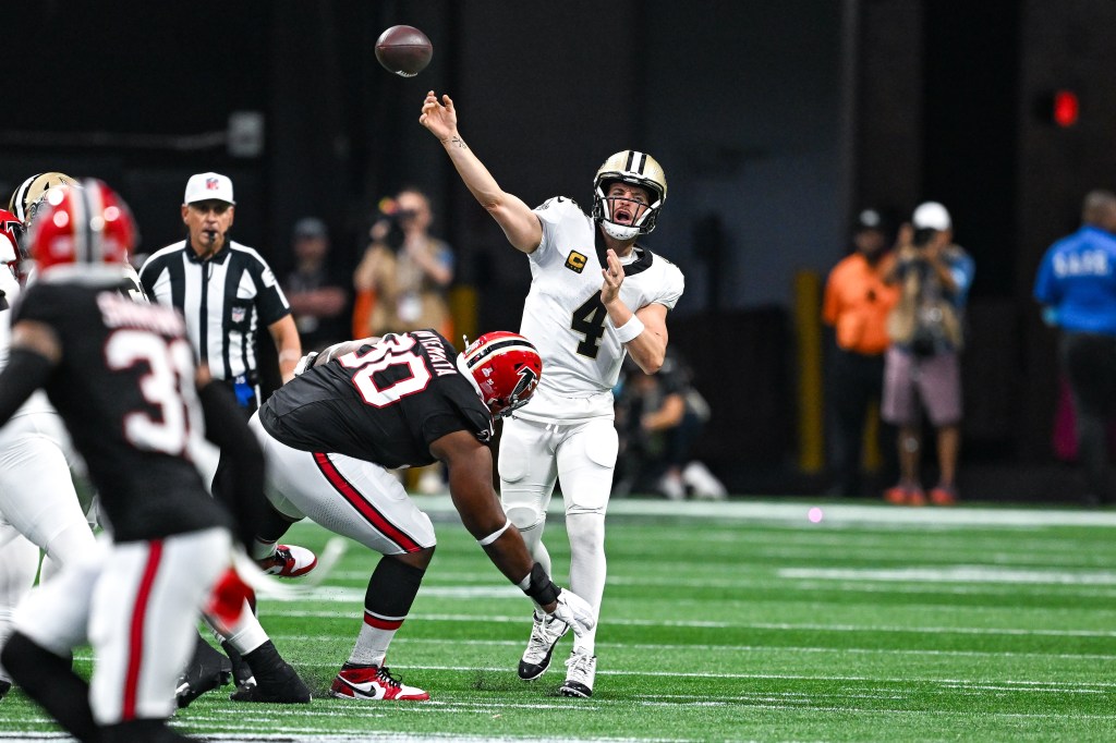 Derek Carr throws a pass against the Falcons in 2024.