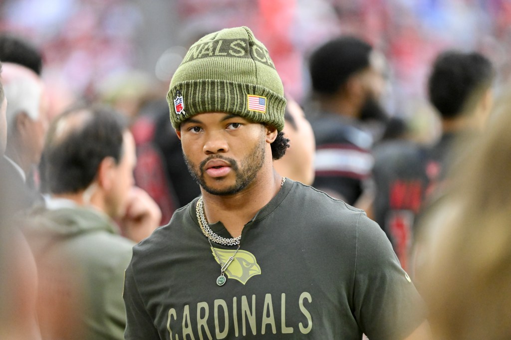Kyler Murray wearing an olive green beanie and matching t-shirt with a Cardinals logo.